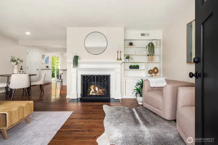 Front entry welcomes you into a living room + dining room with hardwood floors, custom built ins, and statement fireplace (fire added for visual, buyer to verify functionality).