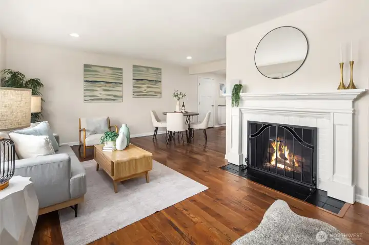 Open living room & dining room with statement fireplace.