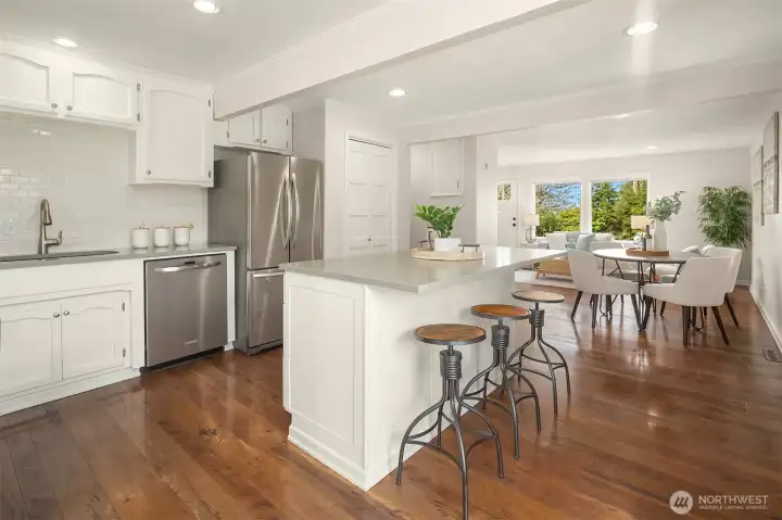 Open kitchen featuring abundant cabinetry, eating area, and barstool seating.