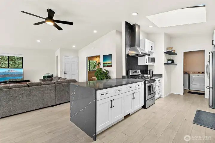 Open-concept kitchen and living area with island seating and a clean, modern layout.