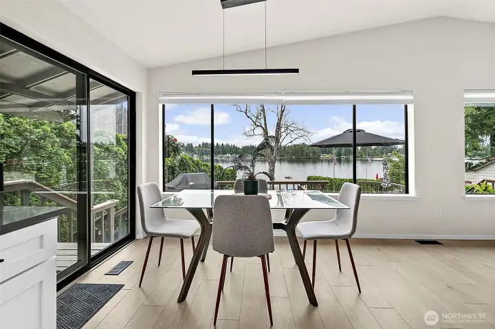 Dining area with sliding door access and a peaceful lake view backdrop.
