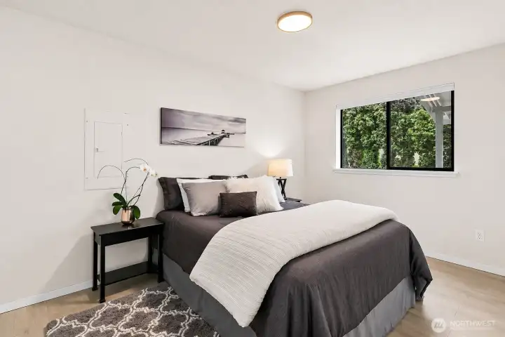 Bright bedroom with neutral finishes and a private window view.