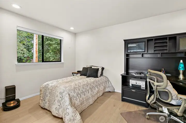 Flexible bedroom or office space with window and built-in storage.