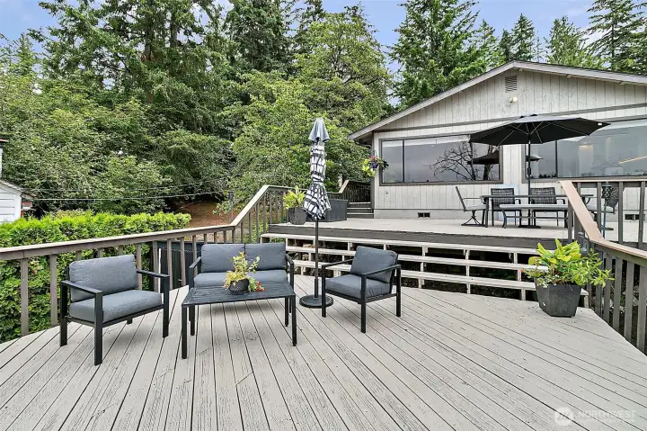 Expansive outdoor deck with seating areas and lake-facing entertaining space.