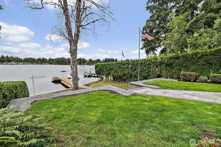 Lakefront yard with dock access, lawn space, and wide Lake Sawyer views.