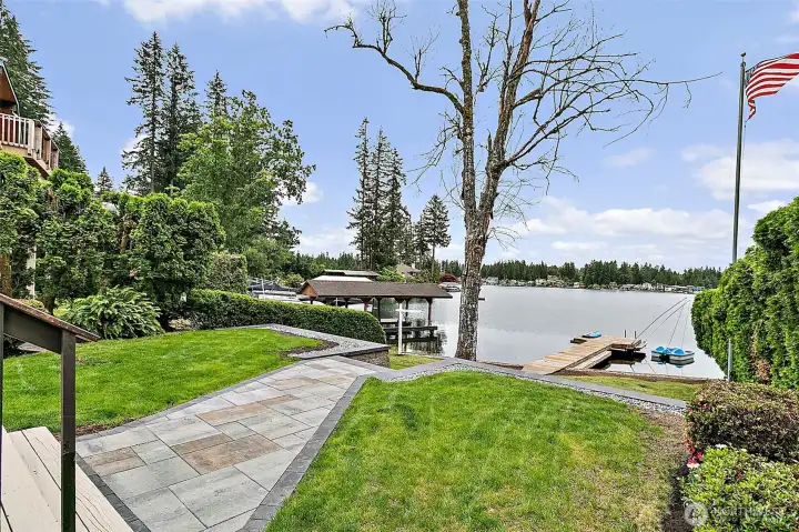 Terraced lakefront yard with dock, lawn, and peaceful water views.