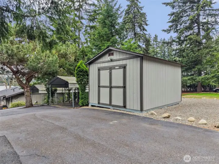 12x16 Tough Shed with nearby carport parking and extra driveway space.