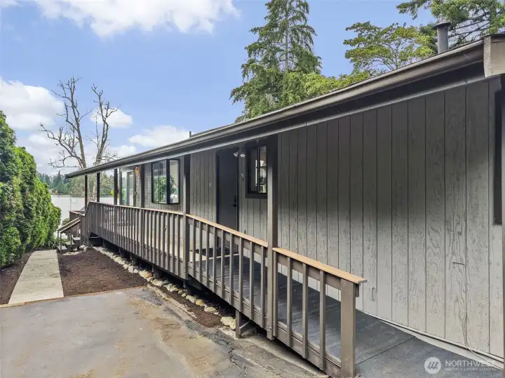 Side entry and covered walkway with lakefront deck access nearby.