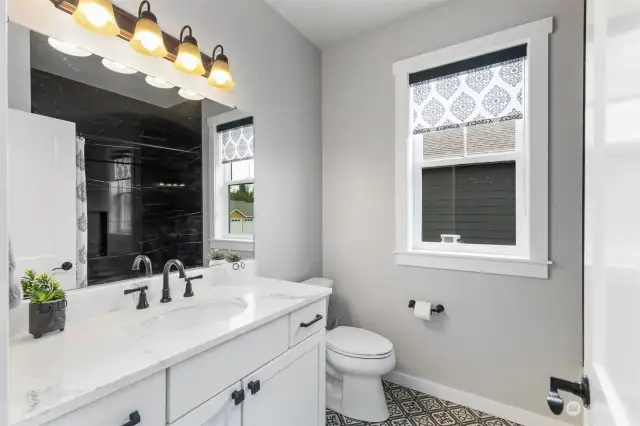 Gorgeous heated tile floors & custom blinds in hall bath.