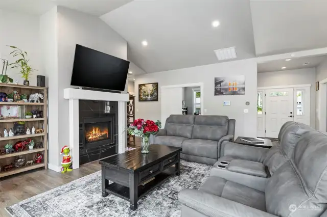 Vaulted ceilings in the great home, with beautiful tile surround on the gas fireplace.