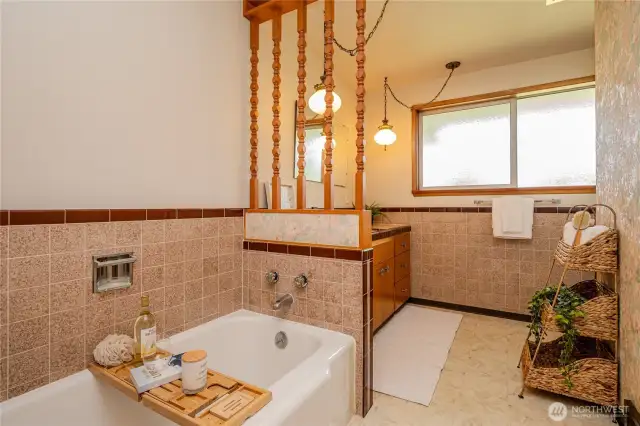 The hall bathroom with ceramic tile surround, vinly tile flooring...