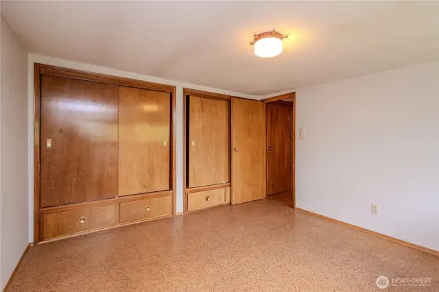 Upstairs Bedroom #4 boasts cedar closets and drawers, Marmoleum tile flooring and pretty backyard views. Extra storage is found at the top of the stairway as well.