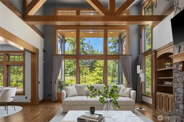 Dramatic floor-to-ceiling windows showcase serene forest vistas, creating a stunning backdrop for refined mountain living.
