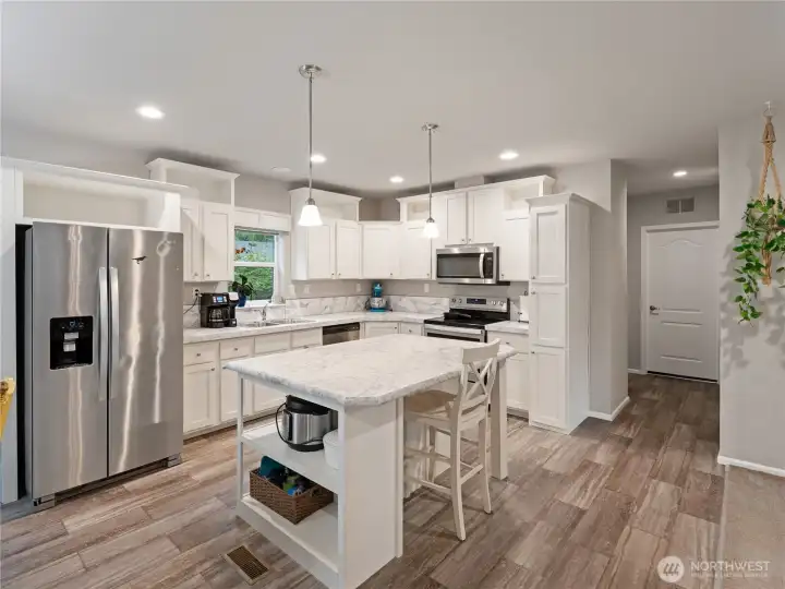 Large kitchen with full sized island and stainless steel appliances