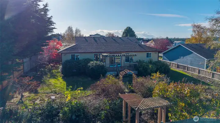 Areial rear yard with bench and tfrellis
