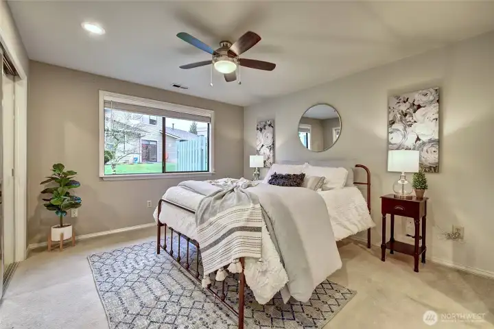 Primary Bedroom. Window faces South. This unit has A/C and the ceiling fan will keep you cool during the summer months.