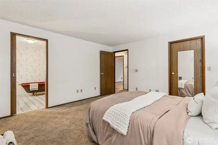 Additional view of primary bedroom with bathroom to the left and walk-in closet to the right