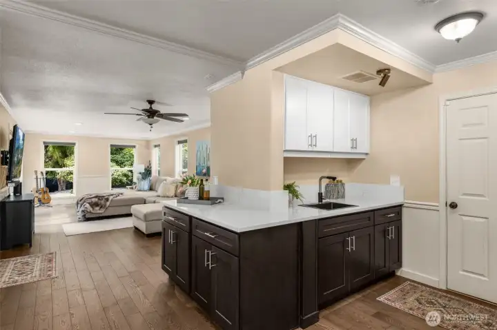 The Kitchen continues with more custom cabinets, additional sink and quartz countertops for big gatherings. Set up to be a possible wine bar.