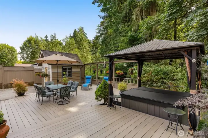 You will enjoy this massive deck with covered Jacuzzi surround by lush trees!