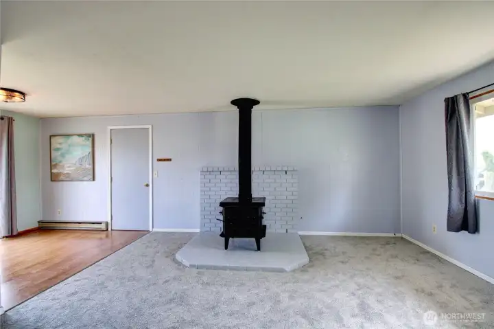 Living room with new carpet, woodstove & dning room adjoining.