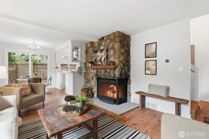 A charming river rock wood-burning fireplace serves as a cozy focal point in the living room.