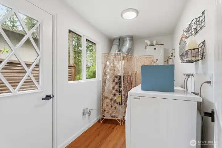 Main floor laundry/utility room with new LVP flooring and direct access to the deck.