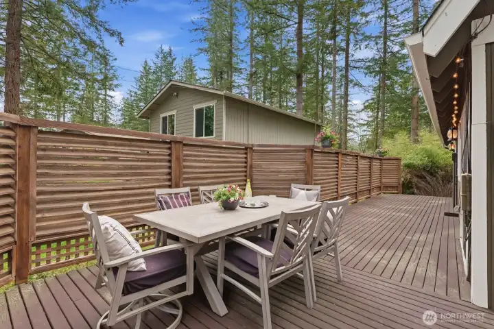 The property is framed by a beautiful wood privacy fence, offering a fully enclosed wraparound yard for added privacy and usability.