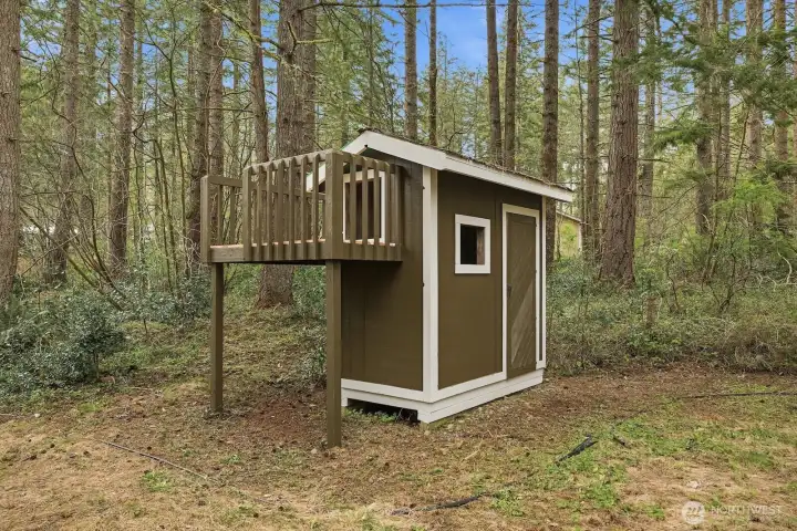 Adorable backyard playhouse adds charm and a fun space for play or creativity.