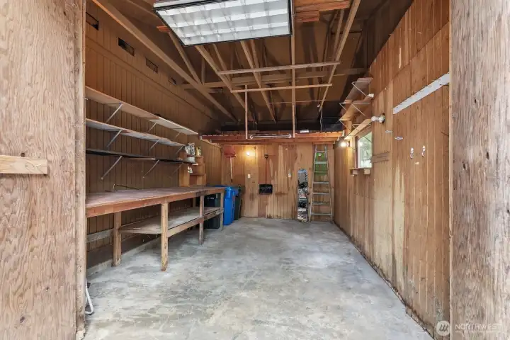 Spacious attached garage offers a workshop/workbench area, built-in shelving, and added loft storage for all your tools and gear.