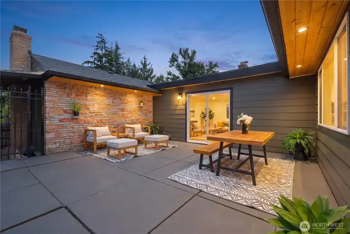 Expansive backyard patio creates multiple outdoor living zones for dining, lounging, and entertaining.