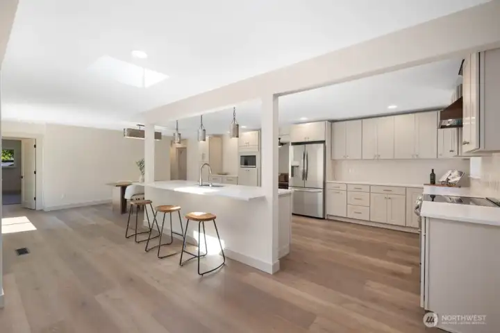 Stunning chef’s kitchen featuring a 9-foot island, Taj Mahal quartzite counters, custom pendants, and bar seating.