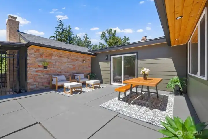 Expansive backyard patio creates multiple outdoor living zones for dining, lounging, and entertaining.