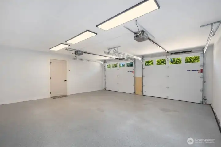 Oversized garage with durable epoxy floor, updated drywall, new doors, and wiring ready for future EV charging.