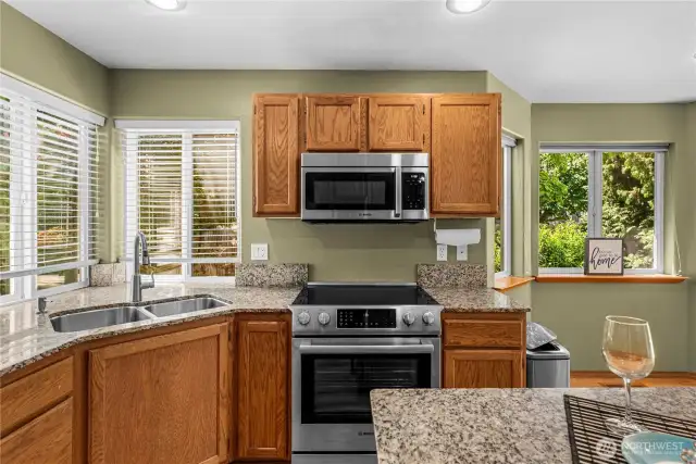 Open kitchen with eat in area with access to family room and deck.