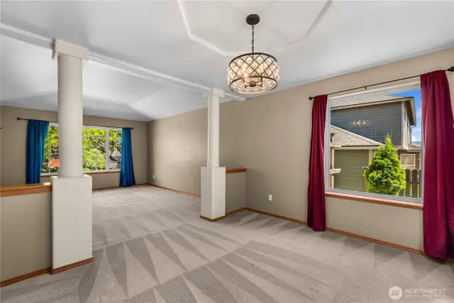 Open concept living and dining room with decorative tray ceilings.