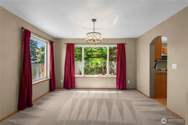 Open concept living and dining room with decorative tray ceilings.