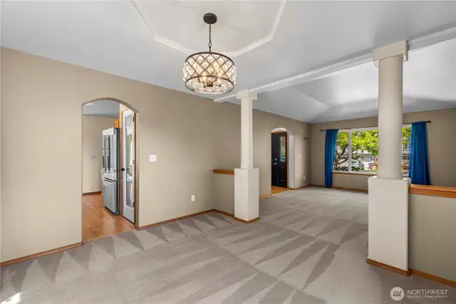 Open concept living and dining room with decorative tray ceilings.