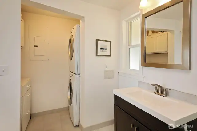 Stackable washer & dryer with additional storage cabinets.