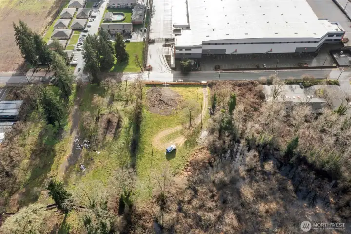 Aerial view of 1 acre almost ready to build property across street from Amazon and Tessla plant.  Property is mostly flat with all utillties connected. It also has new 6ft cedar fence in front for privacy