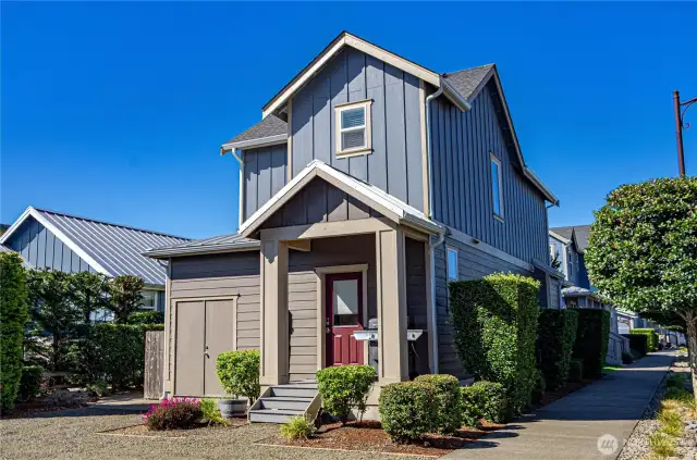 Back entrance of home with covered stoop and attached storage closet
