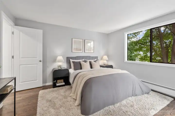 Retreat to your spacious primary bedroom, large enough to fit a king sized bed that overlooks greenery.