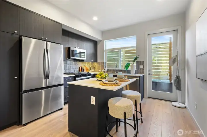 The chef-inspired kitchen features a large island with seating, stainless steel appliances, and designer cabinetry.
