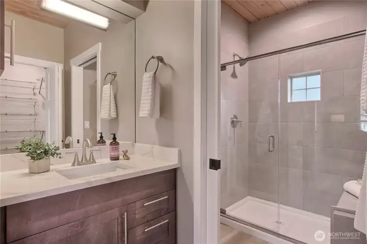 Primary bath with tiled shower and seating bench.