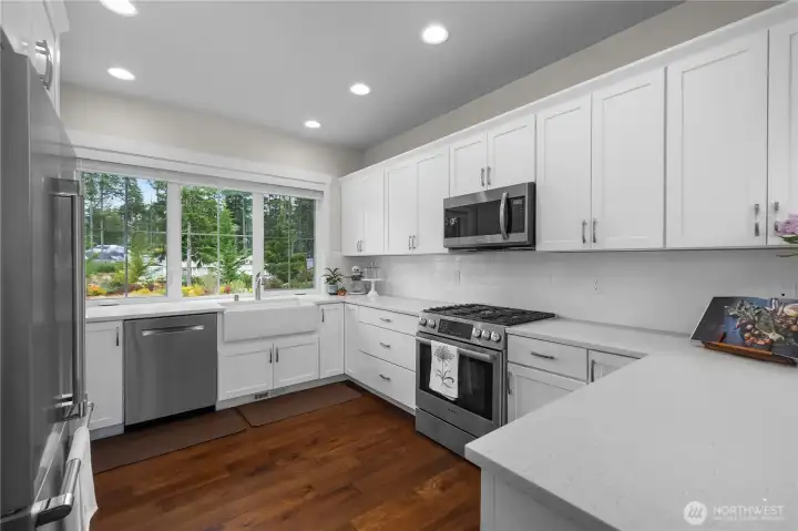 The peninsula kitchen features quartz counters, a Bosch duel fuel range, plenty of cabinetry with pullouts & soft close drawers and a breakfast bar.