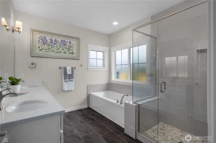 Primary five piece bath features quartz tops & a full tile shower surround.