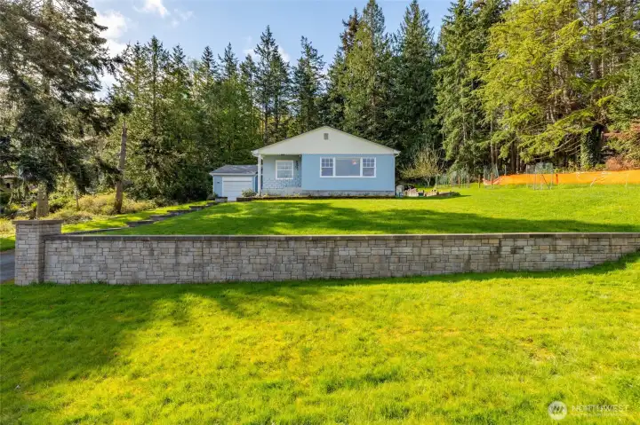 Newly installed rock retaining wall frames in part of the front yard.