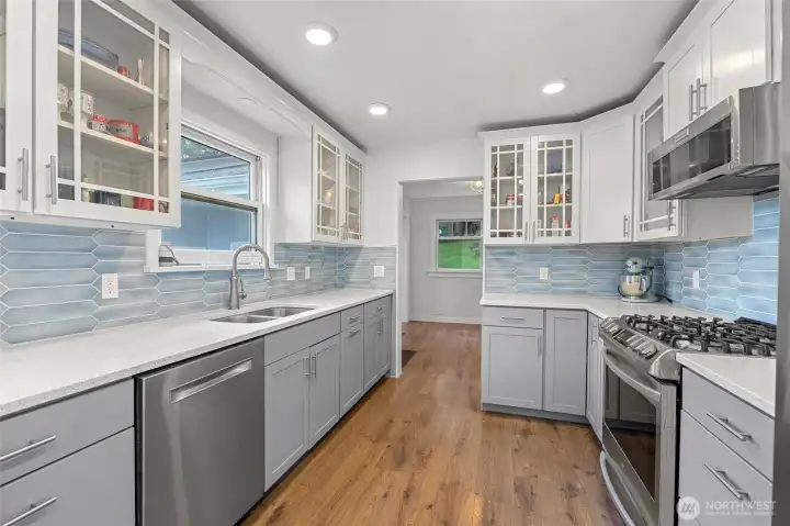 Gorgeous updated kitchen. 5 burner gas cook top, tile backsplash and shaker cabinets.