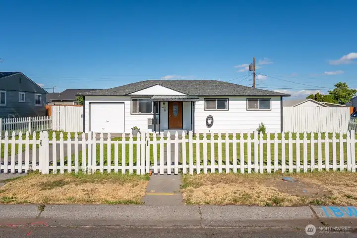 White picket fence and an adorable home.