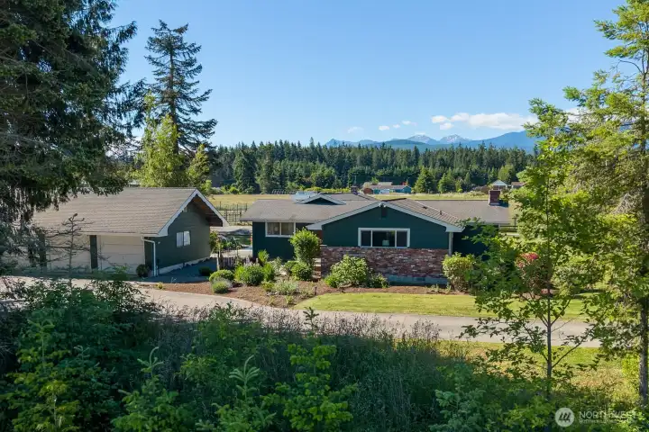 View of Beautiful Ranch Home and 3 car Detached Garage from North side. Full circular driveway, Mountain views