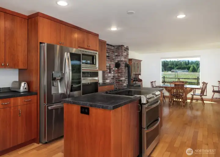 Kitchen with tons of cabinetry, center island, eating nook, upgraded appliances including double ovens